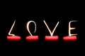 LOVE written with candle flames on black