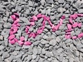 Love - written in colored stones on gray gravel, background, texture Royalty Free Stock Photo