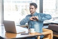 Love you! Portrait of romantic happy young boyfriend in blue jeans shirt are sitting in cafe and showing his girlfriend a heart Royalty Free Stock Photo