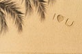 Love you text hand-drawn, palm tree branch shadow on sand tropical beach. valentines day. Beach, travel, summer, holiday concept Royalty Free Stock Photo