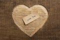 Love you - tiny typed text note close up. Valentines Day greetings concept. Carved heart shape on wood as background for Royalty Free Stock Photo