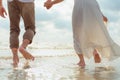 Love young couple barefoot running on the beach. Holiday and vocation concept