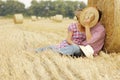 In love young couple on haystacks in cowboy hats Royalty Free Stock Photo