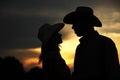 In love young couple on haystacks in cowboy hats Royalty Free Stock Photo