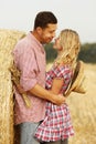 In love young couple on haystacks in cowboy hats Royalty Free Stock Photo