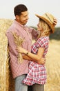 In love young couple on haystacks in cowboy hats Royalty Free Stock Photo