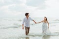 Love young couple holding hands and running on the beach. Holiday and vocation concept
