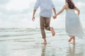 Love young couple holding hands and running on the beach. Holiday and vocation concept