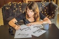 Love yourself. Calligrapher Young Woman writes phrase on white paper. Inscribing ornamental decorated letters