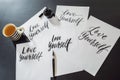 Love yourself. Calligrapher Young Woman writes phrase on white paper. Inscribing ornamental decorated letters