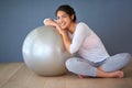 Love yourself enough to live a healthy life. Full length shot of a sporty young woman leaning on a pilates ball against Royalty Free Stock Photo