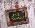 Love yourself written on Vintage sign board Royalty Free Stock Photo