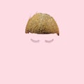Lovely abstract coconut half with funky pair of eyelashes. Baby pink background. Optimistic minimal modern concept