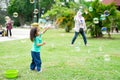 Lovely active little asian girl playing with soap bubble outdoor in the park Royalty Free Stock Photo