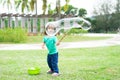 Lovely active little asian girl playing with soap bubble outdoor in the park Royalty Free Stock Photo