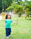 Lovely active little asian girl playing with soap bubble outdoor in the park Royalty Free Stock Photo