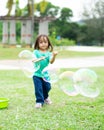 Lovely active little asian girl playing with soap bubble outdoor in the park Royalty Free Stock Photo