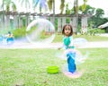 Lovely active little asian girl playing with soap bubble outdoor in the park Royalty Free Stock Photo