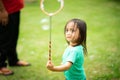 Lovely active little asian girl playing with soap bubble outdoor in the park Royalty Free Stock Photo