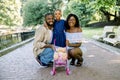 Lovely African family with small daughter, wearing stylish casual clothes and dress, standing outdoors in summer sunny Royalty Free Stock Photo