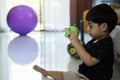 Lovely Asian baby boy sit and playing with soccer ball on floor at home Royalty Free Stock Photo