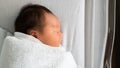 Lovely Asian baby infant sleeping on soft bed. portrait of newborn child covered with blanket in hospital basket. Royalty Free Stock Photo