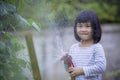 lovely asian children pouring water to home garden vegetable plant with happiness face