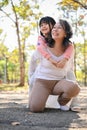 Lovely Asian grandmother and her granddaughter playing in the park together, piggy back Royalty Free Stock Photo