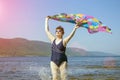 Athletic elderly woman runs along the waves on a summer sunny day against the background of mountains Royalty Free Stock Photo