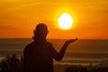 Lovely athletic mature woman holding the sun in her palm