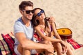 Lovely attractive couple sitting together on the beach having vacation. Cute youbg family resting Royalty Free Stock Photo