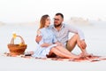 lovely attractive couple sitting together on the white sand beach, happy couple sitting on a blanket , happy couple enjoying Royalty Free Stock Photo