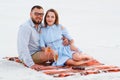 lovely attractive couple sitting together on the white sand beach, happy couple sitting on a blanket , happy couple enjoying Royalty Free Stock Photo