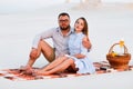 Lovely attractive couple sitting together on the white sand beach Royalty Free Stock Photo