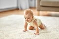 Lovely baby girl crawling on floor at home Royalty Free Stock Photo
