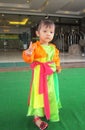 A lovely baby girl is playing in the street with a Vietnamese traditional four-part dress