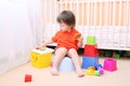 Lovely baby plays toys sitting on potty