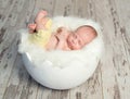 Lovely baby in yellow pants on white cot like shell