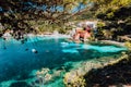 Lovely bay of assos village, Kefalonia, Greece. View on tourquise transparent water framed between green pine grove