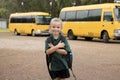 Beautiful blond Caucasian female child waiting for school bus carrying backpack smiling happy in student young girl and schoolgirl