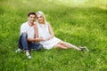 The lovely couple in love sitting on green grass. Royalty Free Stock Photo