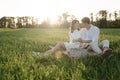 The lovely beautiful couple in love sitting on green grass. Romantic love story in the park. Young girl and boy in love. Royalty Free Stock Photo