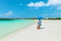 Lovely beautiful view of a young woman walking on white sand tropical Cuban beach along the tranquil, turquoise ocean on sunny bea Royalty Free Stock Photo