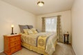 Lovely bedroom interior with yellow bedding, carpet floor and nightstand.