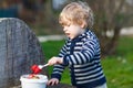 Lovely blond boy of two years eating strawberries outdoors Royalty Free Stock Photo