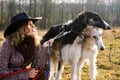 Lovely blond woman with two dogs in a field