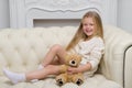 Girl Sitting On Sofa Hugging Teddy Bear
