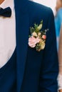 Lovely boutonniere of colourful roses on the jacket of the groom.