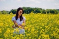 Lovely brunette in sunglasses stay in rapeseed field. Royalty Free Stock Photo