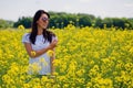 Lovely brunette in sunglasses stay in rapeseed field. Royalty Free Stock Photo